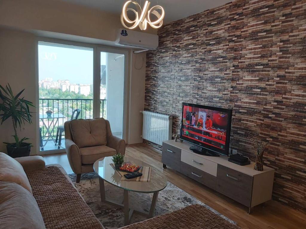 a living room with a tv and a brick wall at Mitreski Impeksel 2 Self Check-in Luxury Apartment in Skopje