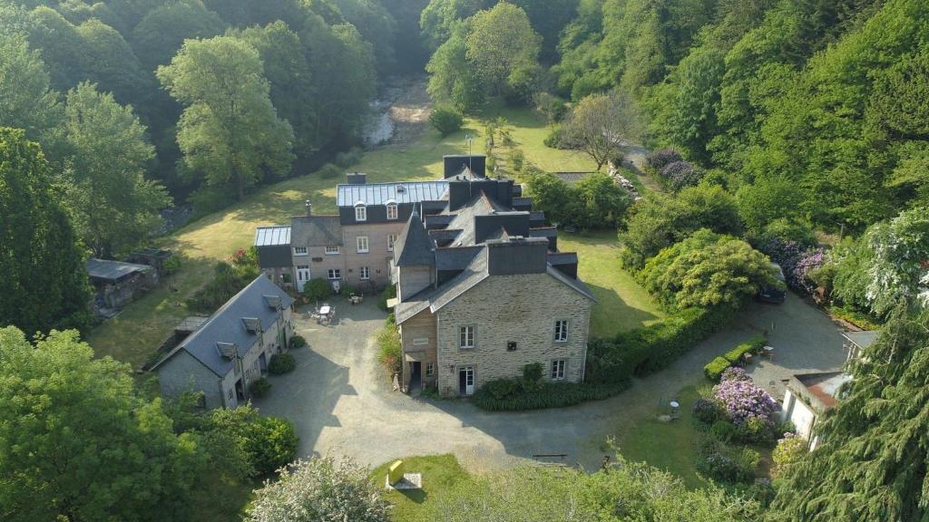 uma vista aérea de uma grande casa numa floresta em Domaine des Papeteries em Plounevez-Moëdec