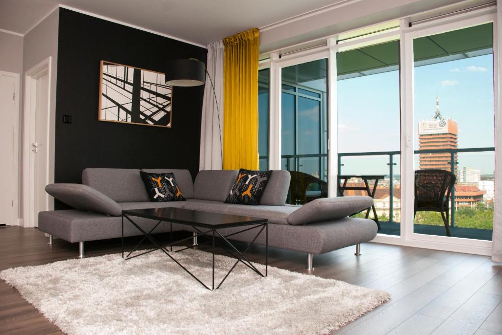 uma sala de estar com um sofá e uma mesa de vidro em Apartamenty I.M.A Towarowa em Poznań