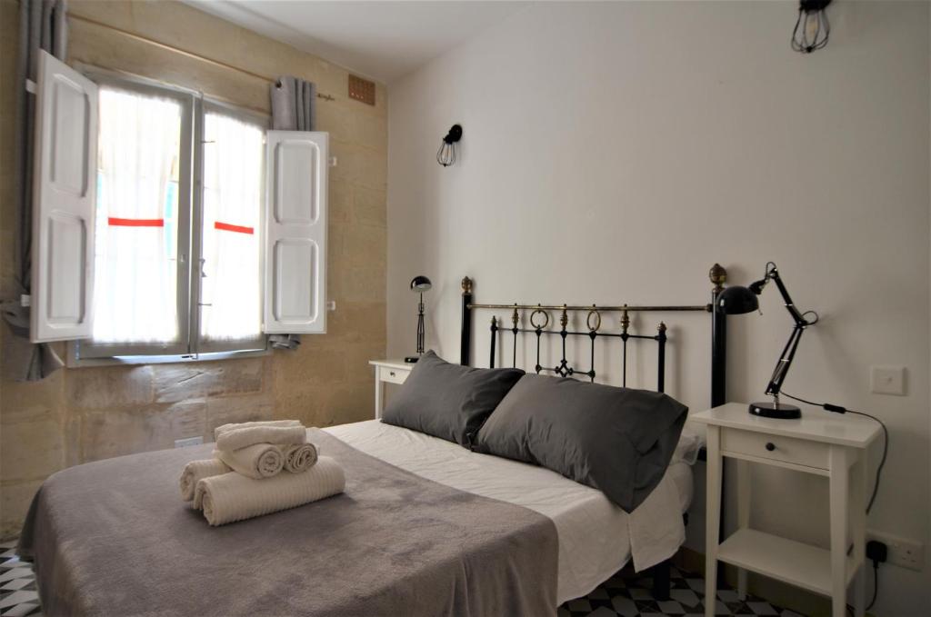 um quarto com uma cama com uma toalha em Città Cospicua suites em Cospicua
