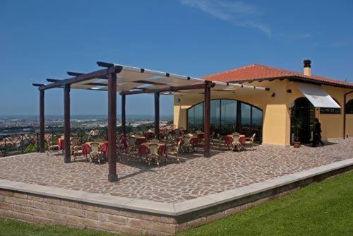 een patio met tafels en stoelen en een gebouw bij La Vista Agriturismo Boutique in Ariccia