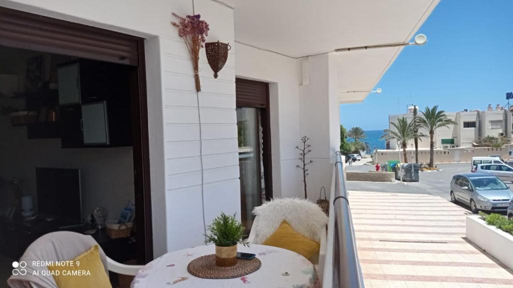 卡沃內拉斯的住宿－LA PITA- Terraza con vistas al mar & parking, a 1 min de la playa，阳台配有桌子,享有街道的景色