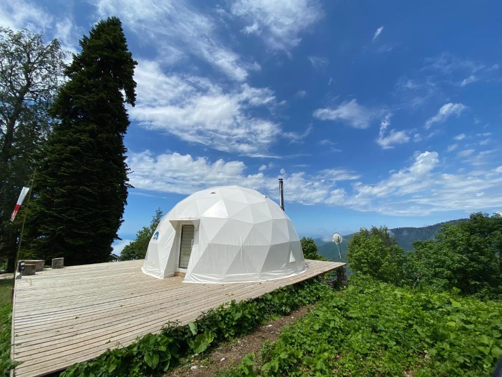 a white dome tent sitting on a wooden deck at Эко-отель АтмоСФЕРА in Gagra