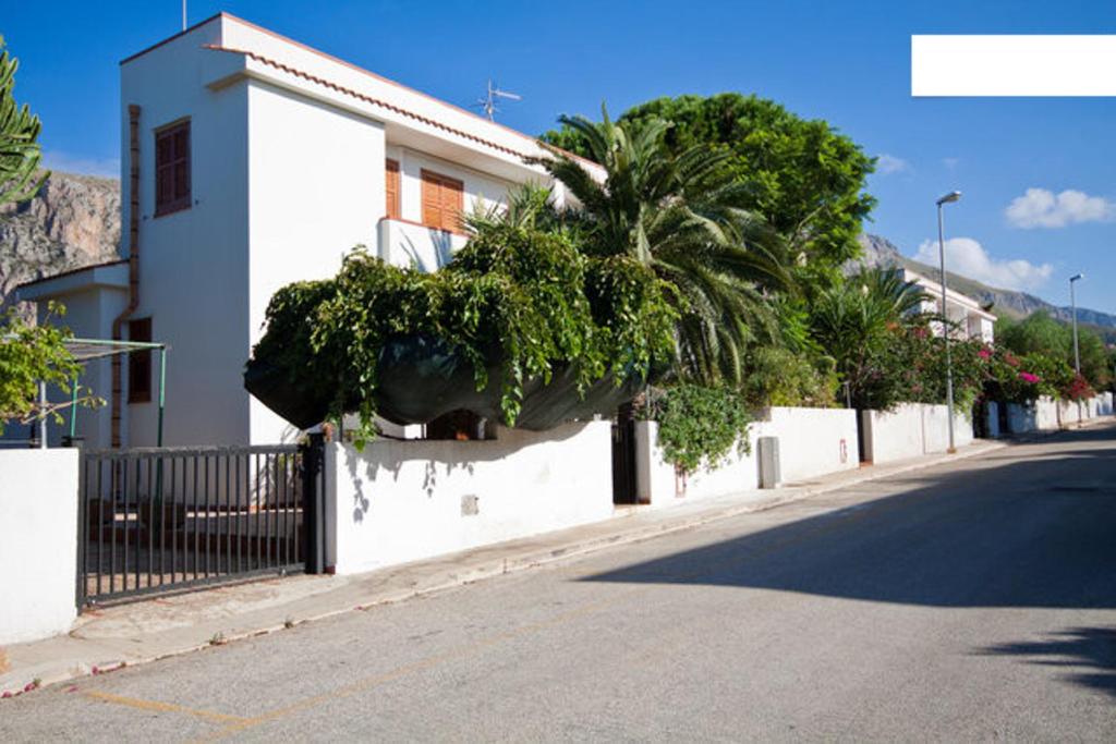 een straat met een wit gebouw en palmbomen bij Villetta a 10 minuti, a piedi, dalla spiaggia in San Vito lo Capo