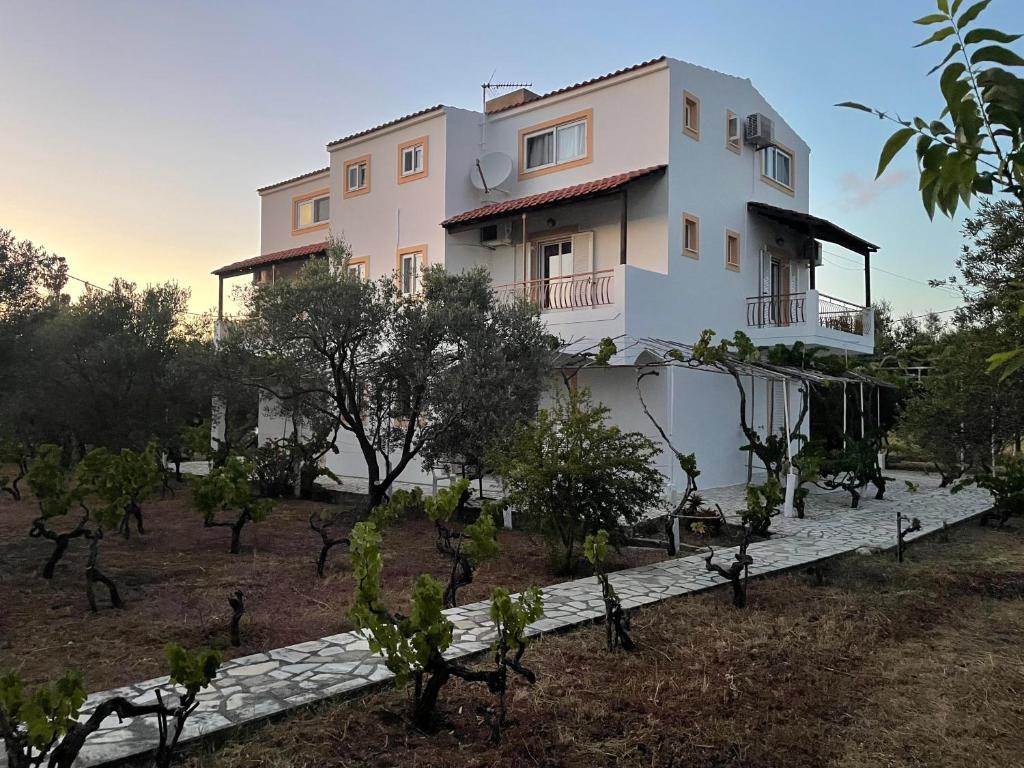 a house in the middle of a field with trees at Andreas Studios in Svoronata