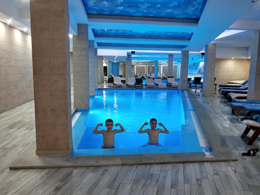 twee kinderen zwemmen in een zwembad in een hotel bij Ski & Spa Apartment S20 Milmari Resort Kopaonik in Kopaonik
