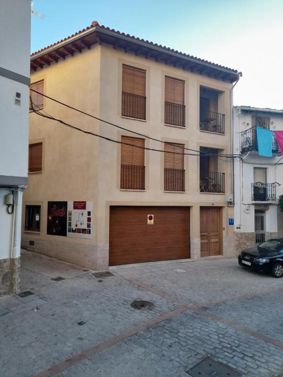 ハライス・デ・ラ・ベラにあるApartamentos Doctor Flemingの二つのガレージドアと正面に駐車した車両のある建物