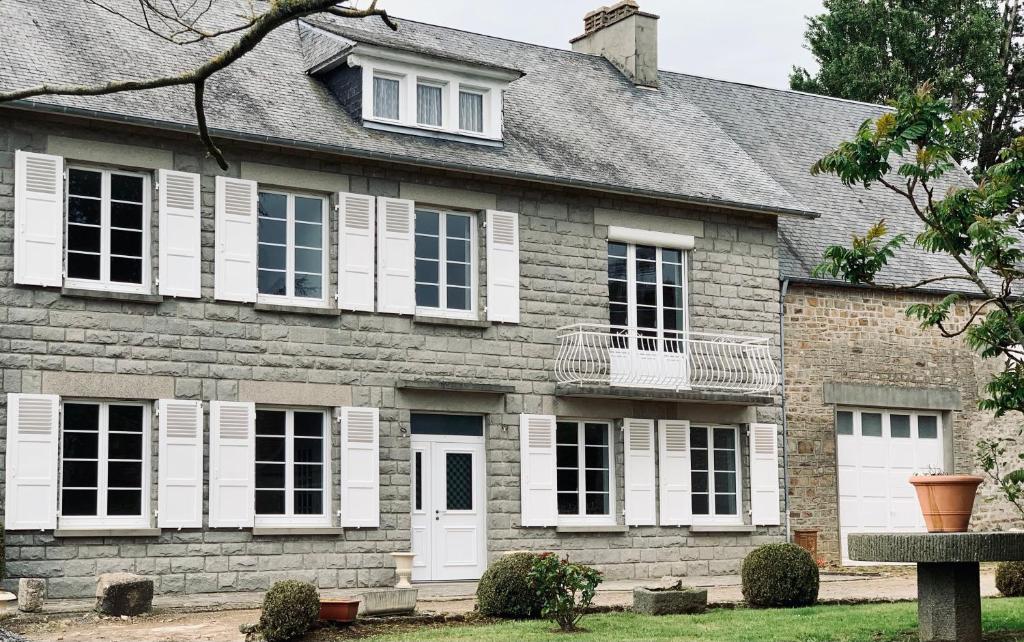 una vieja casa de ladrillo con persianas blancas en LA BUTTE - Maison de vacances Avranches avec vue sur le Mont Saint Michel, en Le Val-Saint-Père