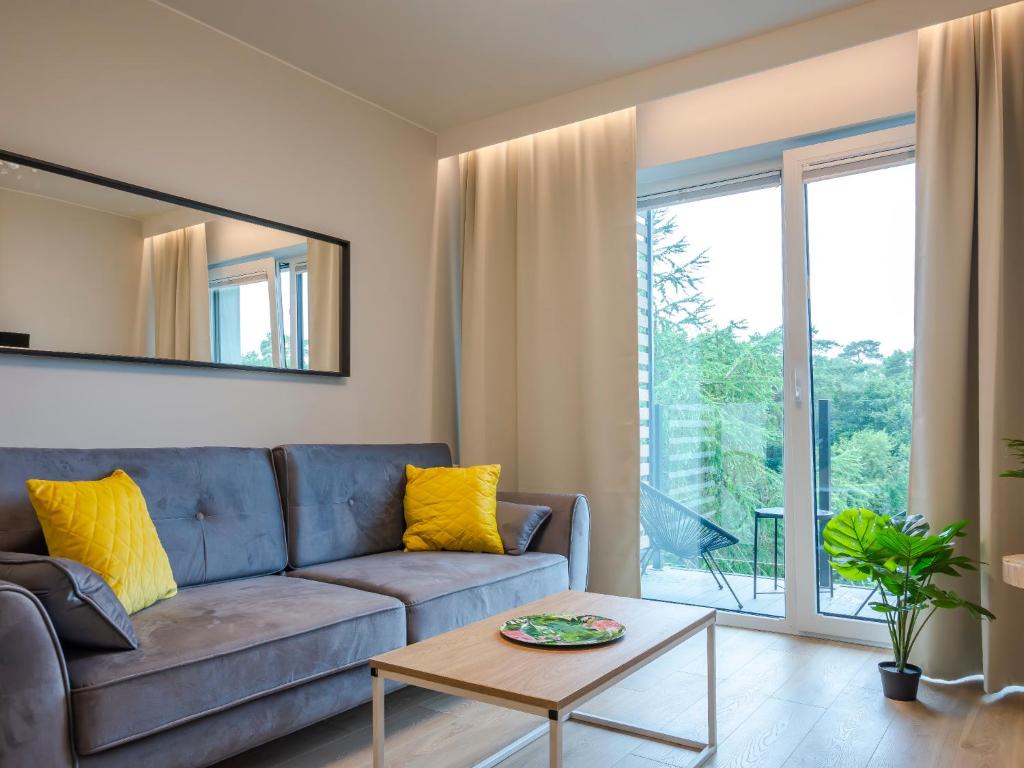 sala de estar con sofá y mesa en VacationClub – Sosnowa 4 Apartament 43 en Mielno