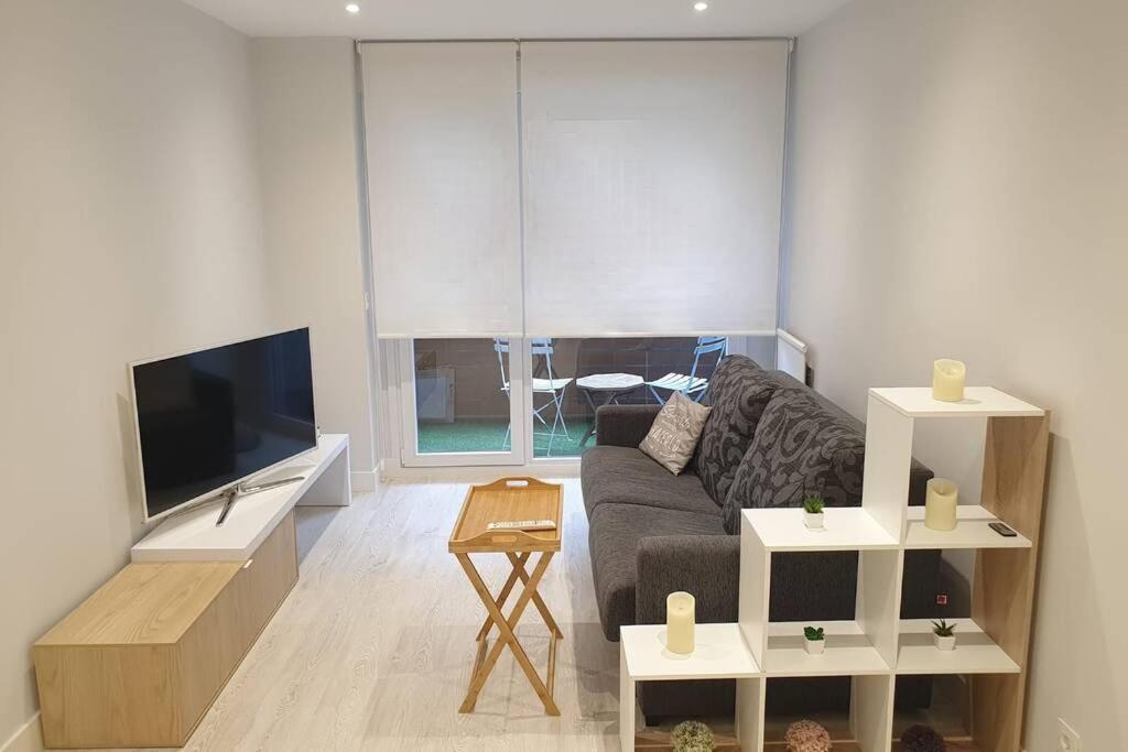 sala de estar con sofá y TV de pantalla plana en Apartamento recién reformado en Barakaldo, en Barakaldo