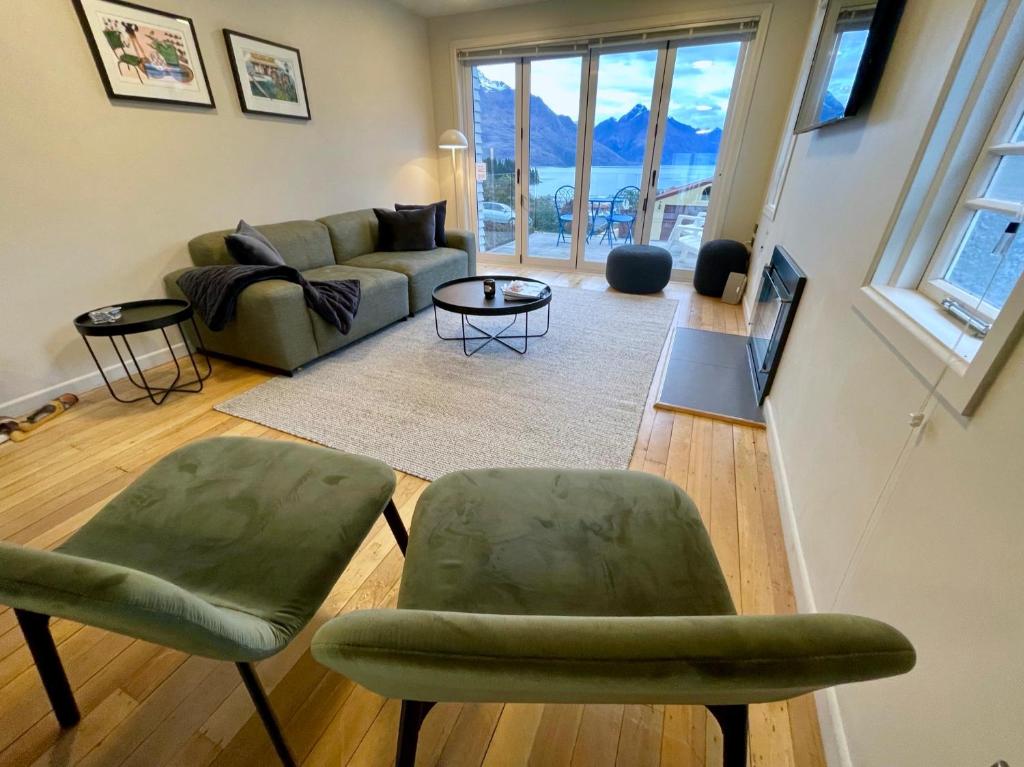 a living room with green chairs and a couch at Villa Queenstown in Queenstown