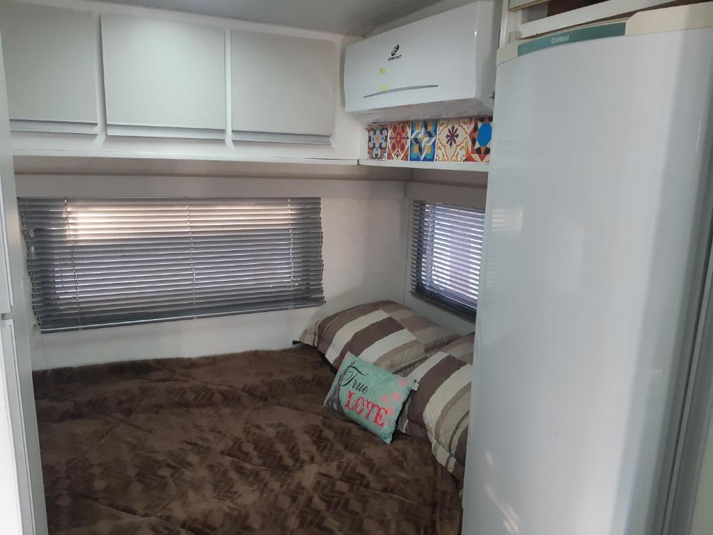 a small bedroom with a bed and a window at Trailer novo completo. in Bagé