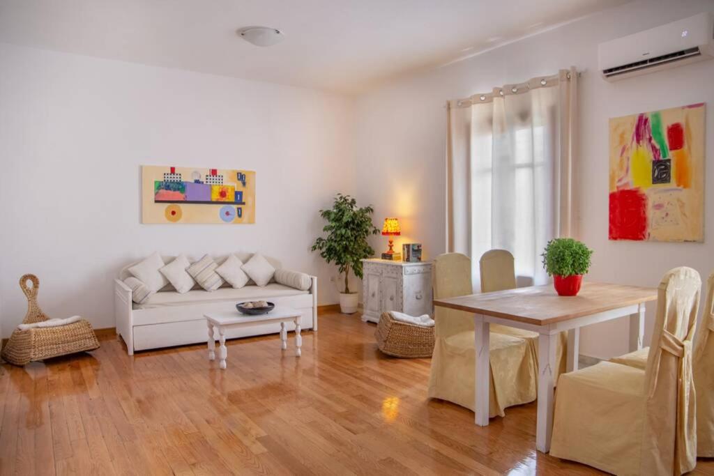salon z białą kanapą i stołem w obiekcie Seaview Stylish Flat in Andros - walk to beach w mieście Andros