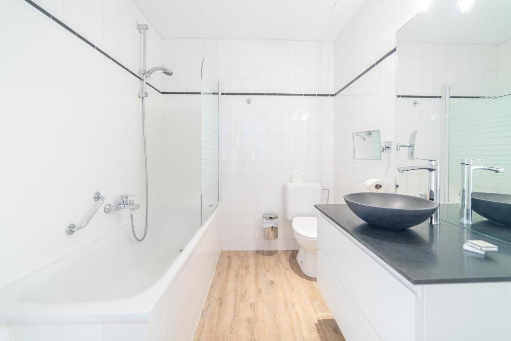 
a bathroom with a tub, sink, and mirror at Hotel Het Gheestelic Hof in Bruges
