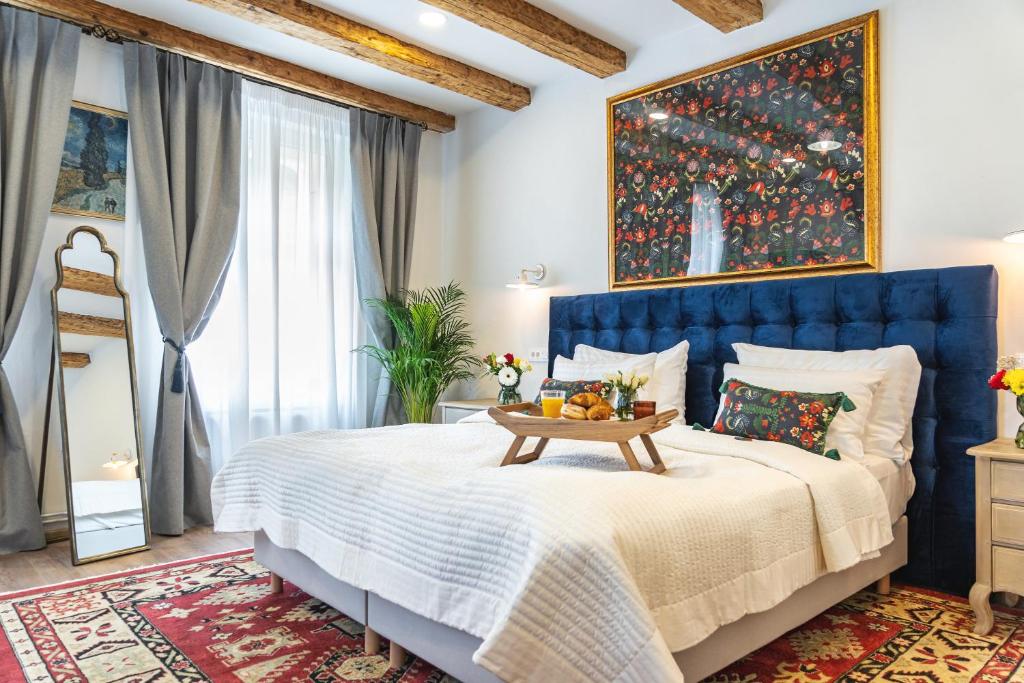 a bedroom with a blue bed with a blue headboard at Nikolas Haus Premium Historic Center Stay & Free Parking in Braşov