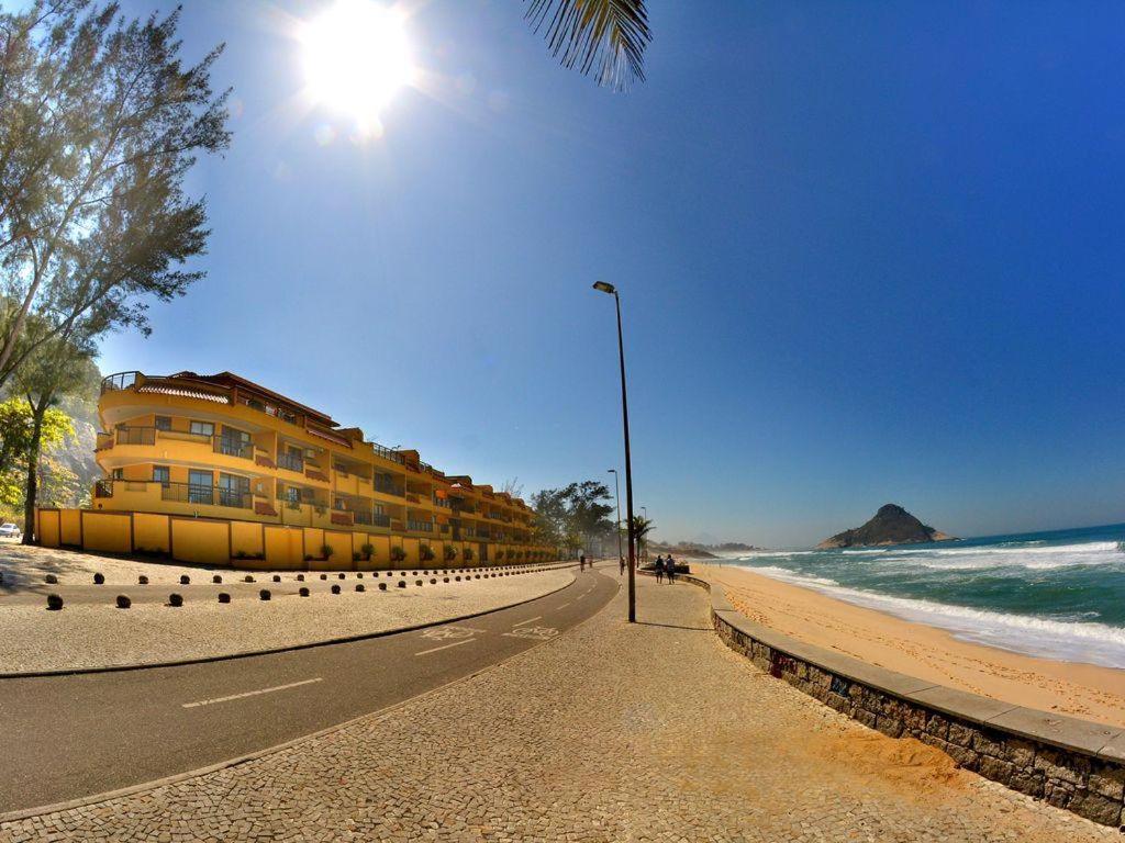 uma praia com um edifício e uma luz de rua e o oceano em Apê Namastê no Rio de Janeiro