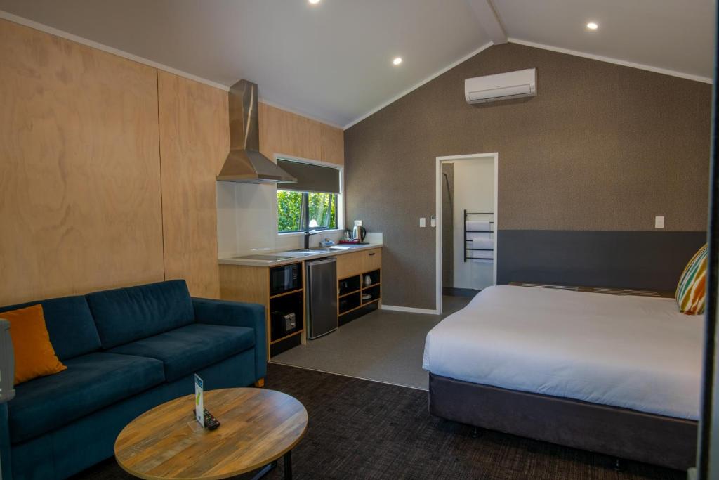 a hotel room with a bed and a couch at Cambridge Top 10 Holiday Park in Cambridge
