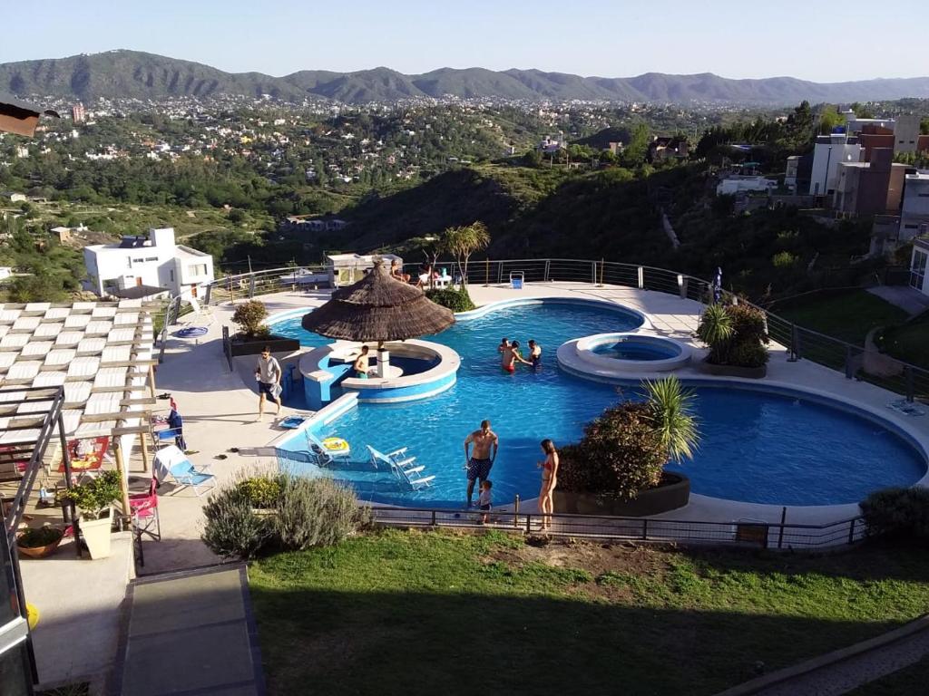 um grupo de pessoas numa piscina num resort em ERNESTINA VILLAGE em Villa Carlos Paz