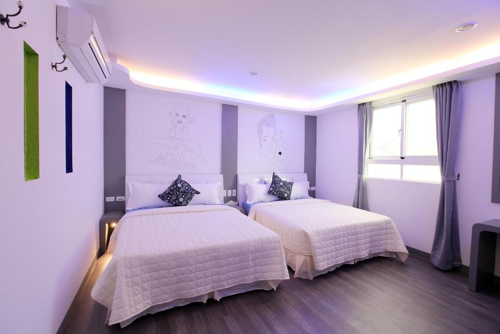 two beds in a room with purple walls at Edinburgh 16 Inn in Hengchun