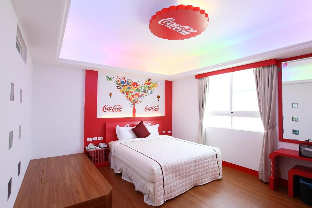 a bedroom with a white bed and a red wall at Edinburgh 16 Inn in Hengchun