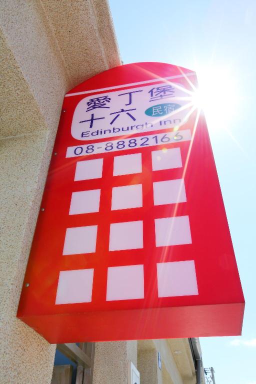 a red sign on the side of a building at Edinburgh 16 Inn in Hengchun