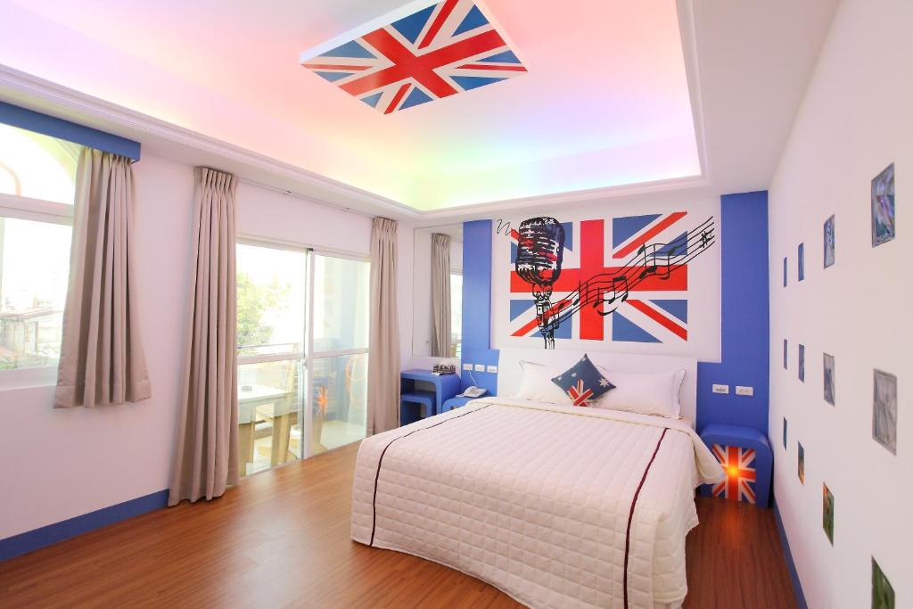 a bedroom with a bed and flags on the wall at Edinburgh 16 Inn in Hengchun South Gate