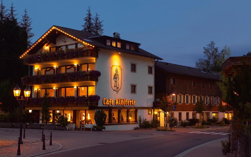 ein großes Gebäude mit einem Schild an der Seite in der Unterkunft Hotel Hirsch mit Café Klösterle in Enzklösterle