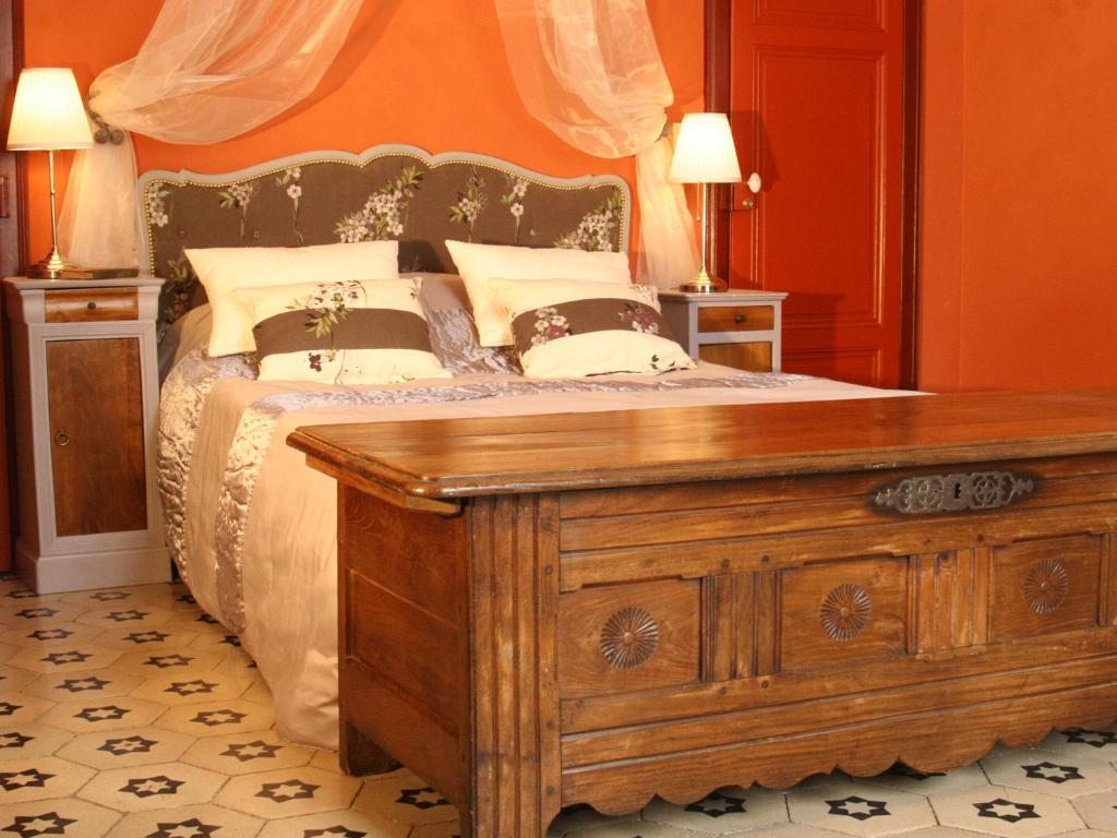 Rieux-MinervoisにあるLes Chambres des Damesのベッドルーム1室(ベッド1台、木製ドレッサー付)