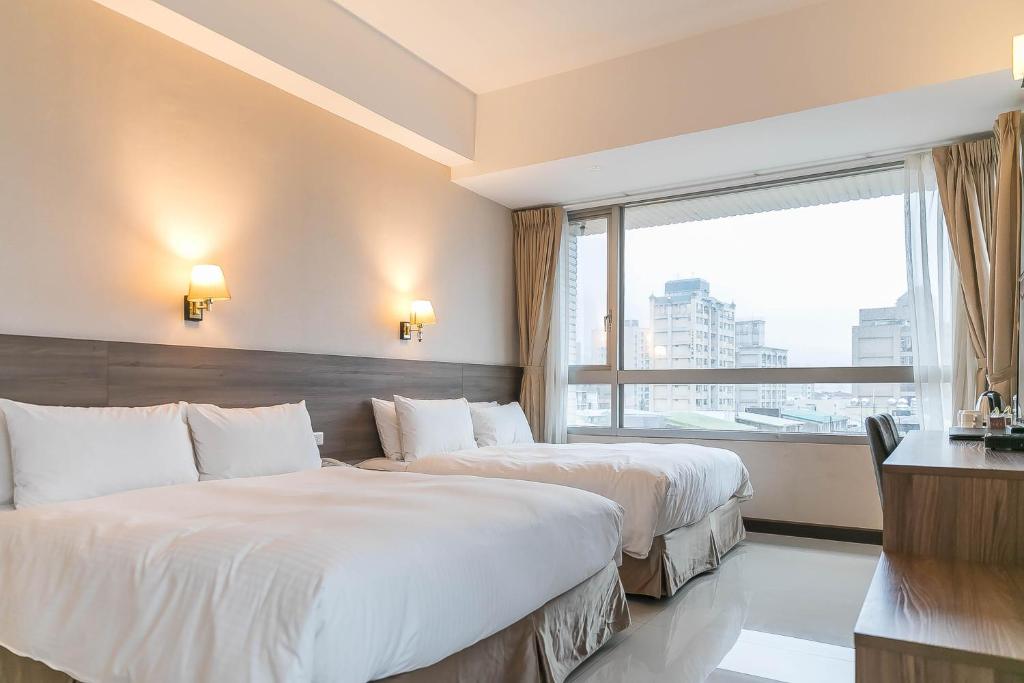 a hotel room with two beds and a window at Hotel Leisure Beitou in Taipei