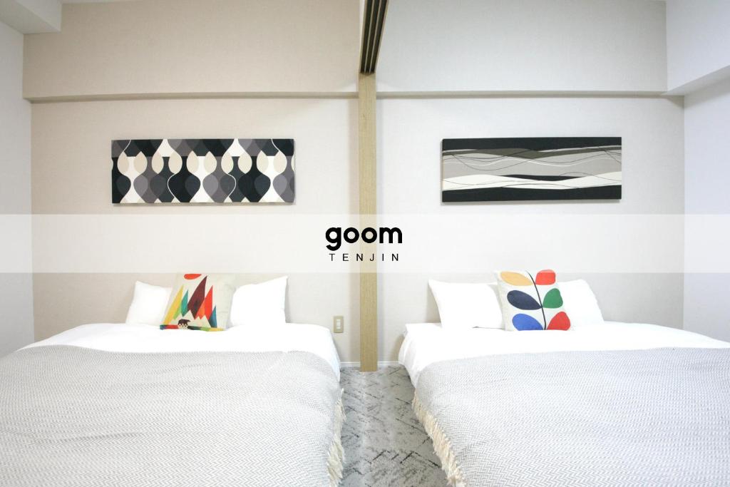 2 camas en una habitación con paredes blancas en goom Hotel Fukuoka-Tenjin, en Fukuoka