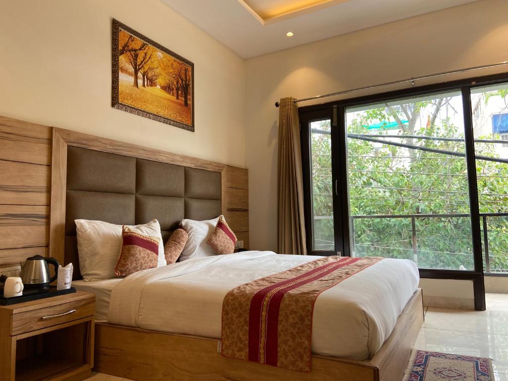 ein Schlafzimmer mit einem großen Bett und einem großen Fenster in der Unterkunft Hotel Exotic - 5 min walk from Golden Temple in Amritsar