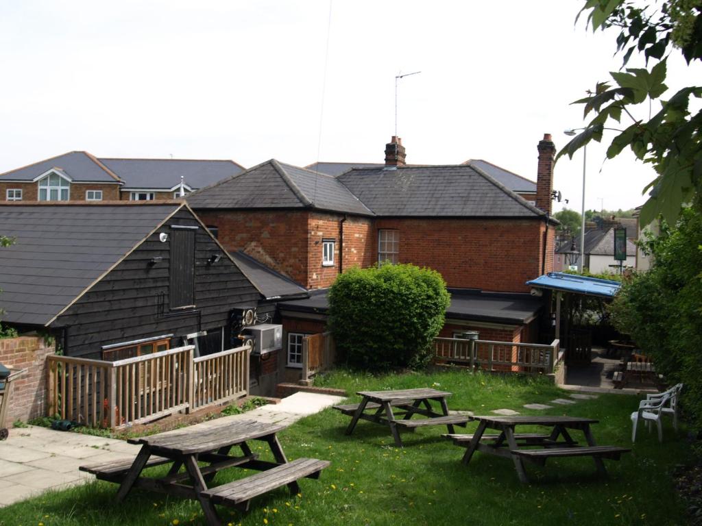 un grupo de mesas de picnic frente a un edificio en Jolly Brewers Free House Inn en Bishops Stortford