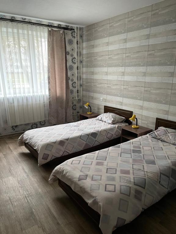 um quarto com 2 camas e uma janela em Strādnieku viesnīca em Ventspils