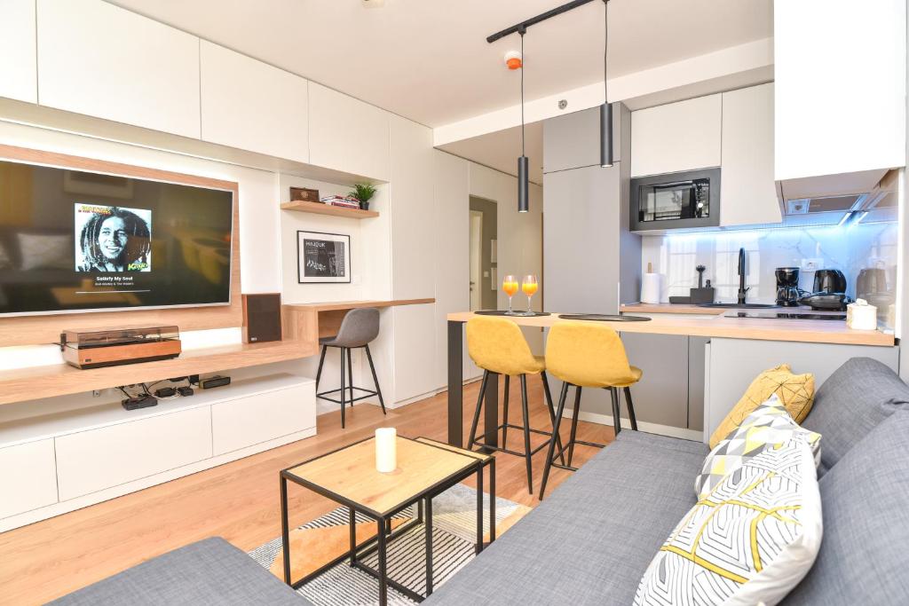 een woonkamer met een grijze bank en een keuken bij Studio apartment Bee One in Dubrovnik