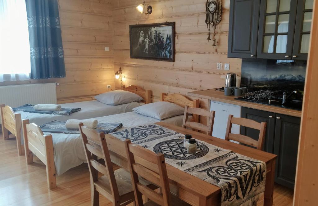 a kitchen with two beds and a table in a room at U Wajdy in Małe Ciche
