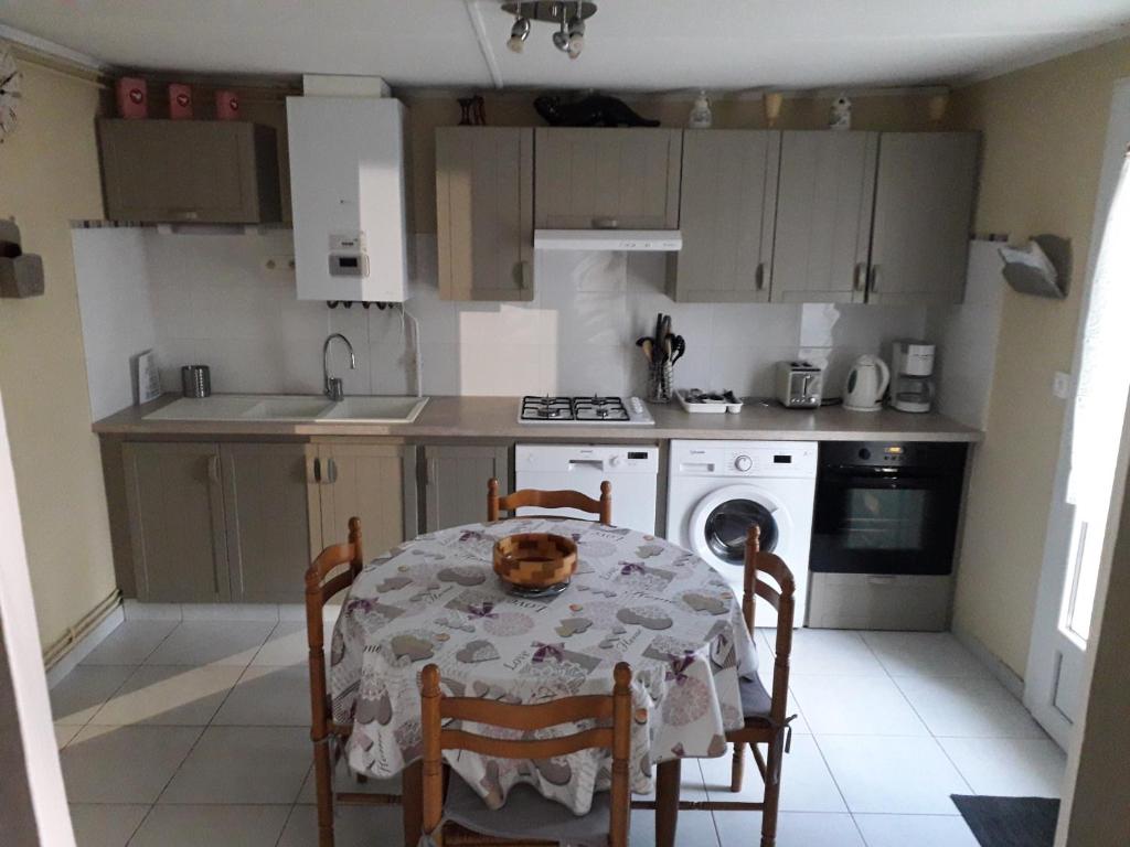 a kitchen with a table and a table and chairs at Maison JMB in Royan