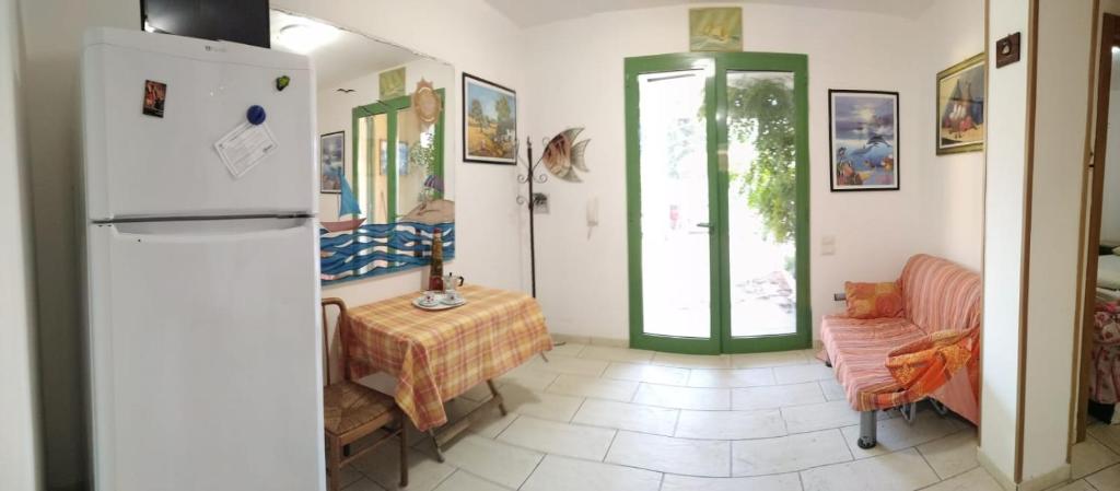 Baia Di GallipoliにあるBaia Verde, Villino indipendenteのキッチン(冷蔵庫、テーブル、椅子付)