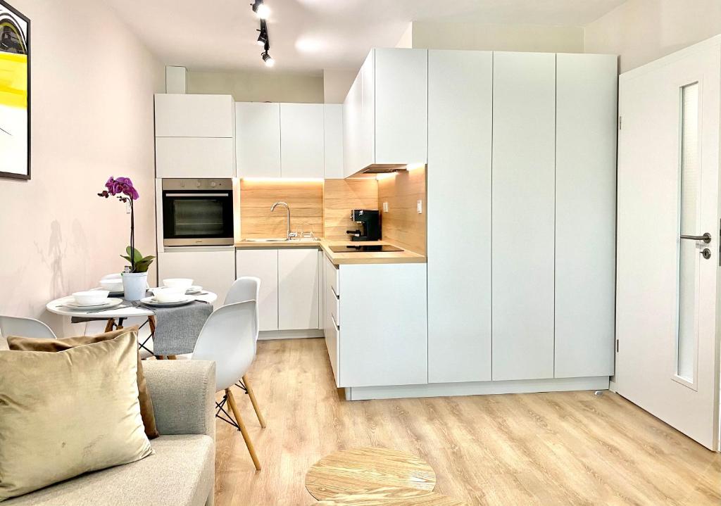 een keuken en eetkamer met witte kasten en een tafel bij City Centre Bright & Cozy Apartment for 4 persons in Stara Zagora