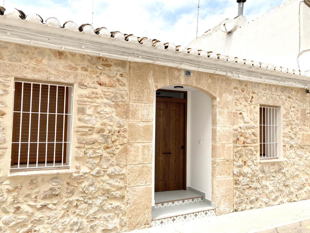 een toegang tot een stenen gebouw met een houten deur bij Ca Tía Teresa in Denia