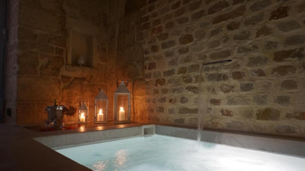 wanna ze świecami w kamiennej ścianie w obiekcie Dimora Acqua di Sale w mieście Bari