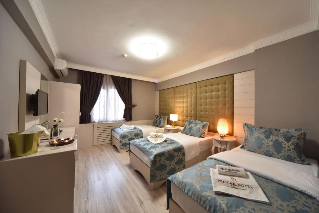 イスタンブールにあるPelican House Hotelのベッド2台とテーブルが備わるホテルルームです。