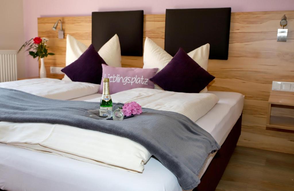 1 dormitorio con 2 camas y 1 botella de champán en Lohauserhof - Biohof und Hotel, en Röhrmoos