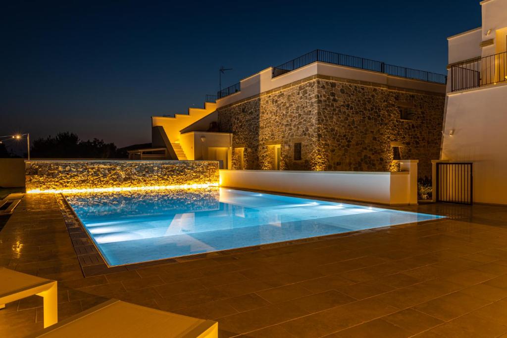 a villa with a swimming pool at night at Dimora Le Site in Torre Suda
