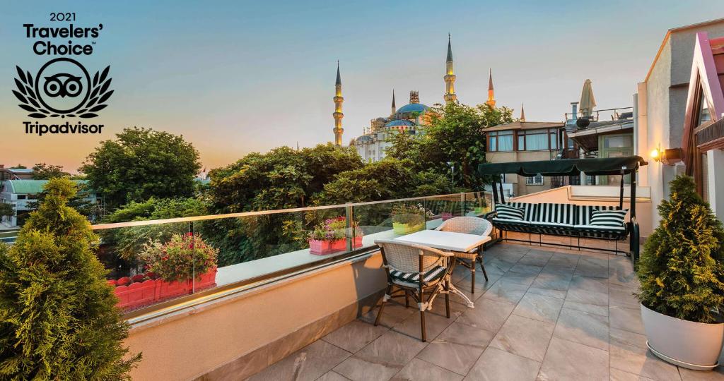a balcony with a table and chairs and a view of a mosque at Obelisk Hotel & Suites in Istanbul
