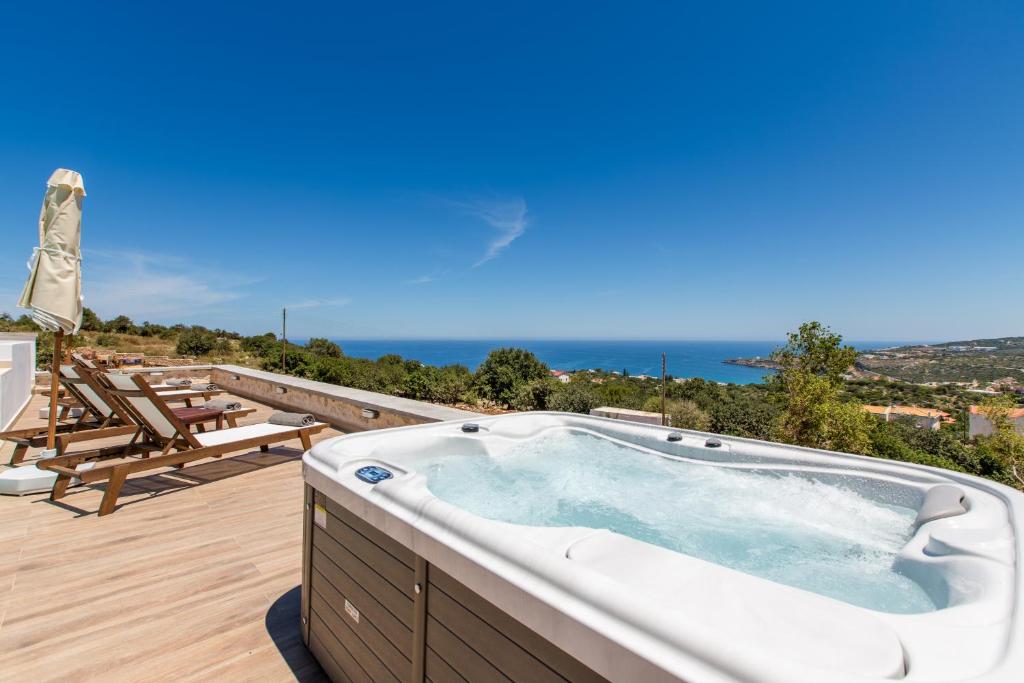 bañera de hidromasaje en una terraza con vistas al océano en Kallixeni Villas, en Rethymno