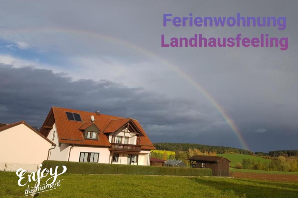 un arco iris en el cielo sobre una casa en Ferienwohnung Landhausfeeling, en Bad Abbach