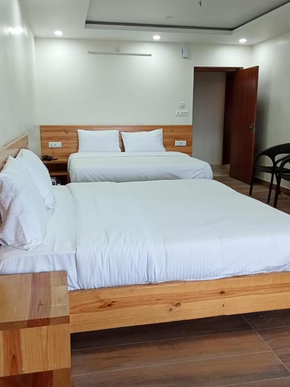 a bedroom with two beds with white sheets at The Kumaon Retreat in Nainital