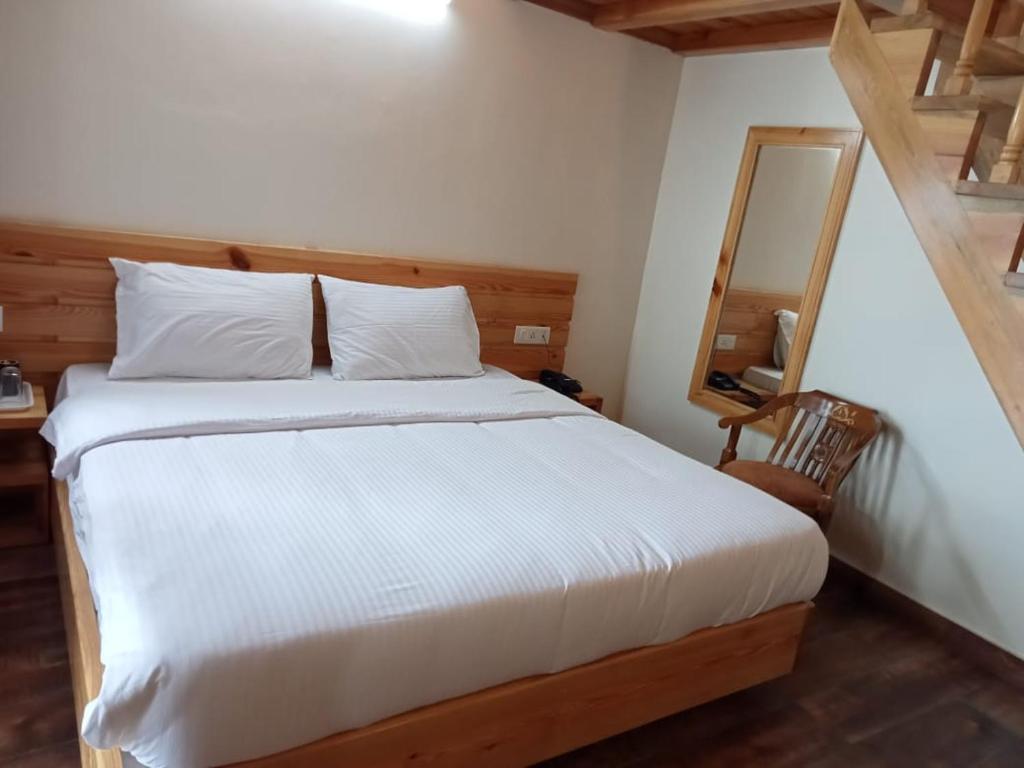 a bedroom with a white bed and a mirror at The Kumaon Retreat in Nainital