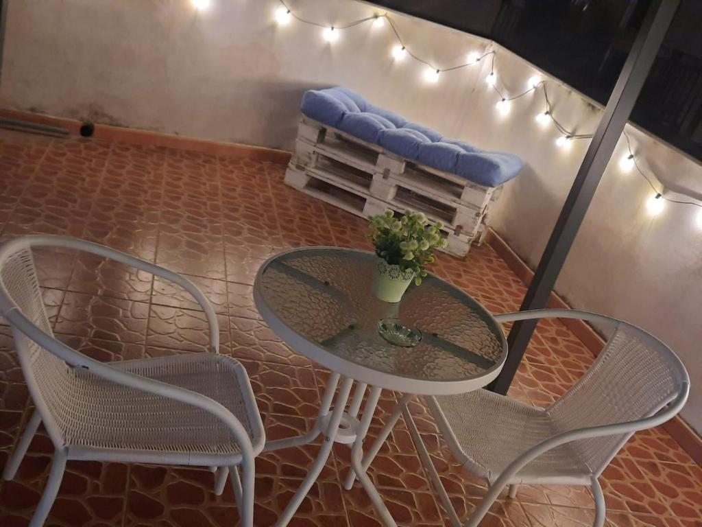 una mesa con sillas y un banco con un cojín azul en La terrazza sul vicolo, en Palermo