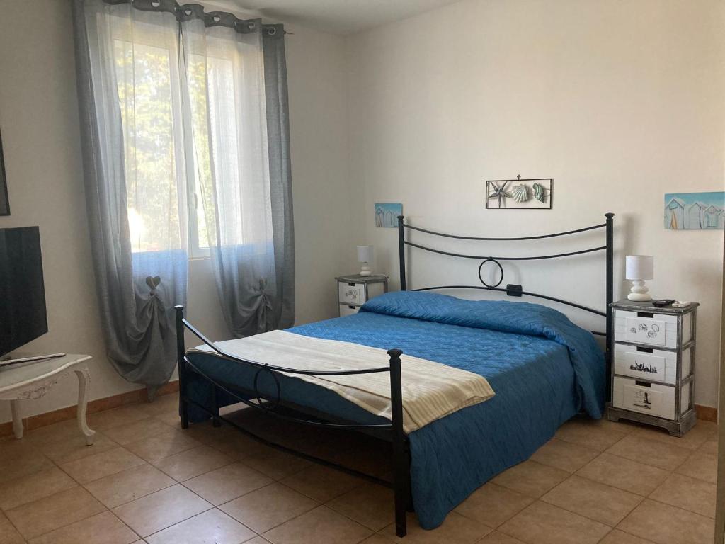 um quarto com uma cama azul e uma televisão em Pineta em Sabaudia